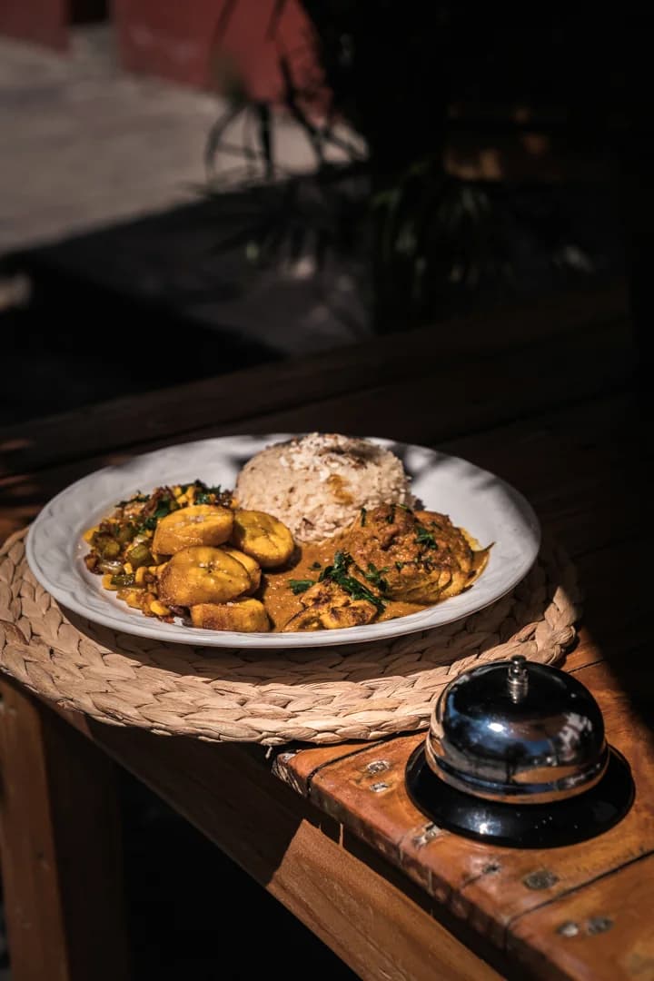 Curry served with rice and vegetables on a wooden table.