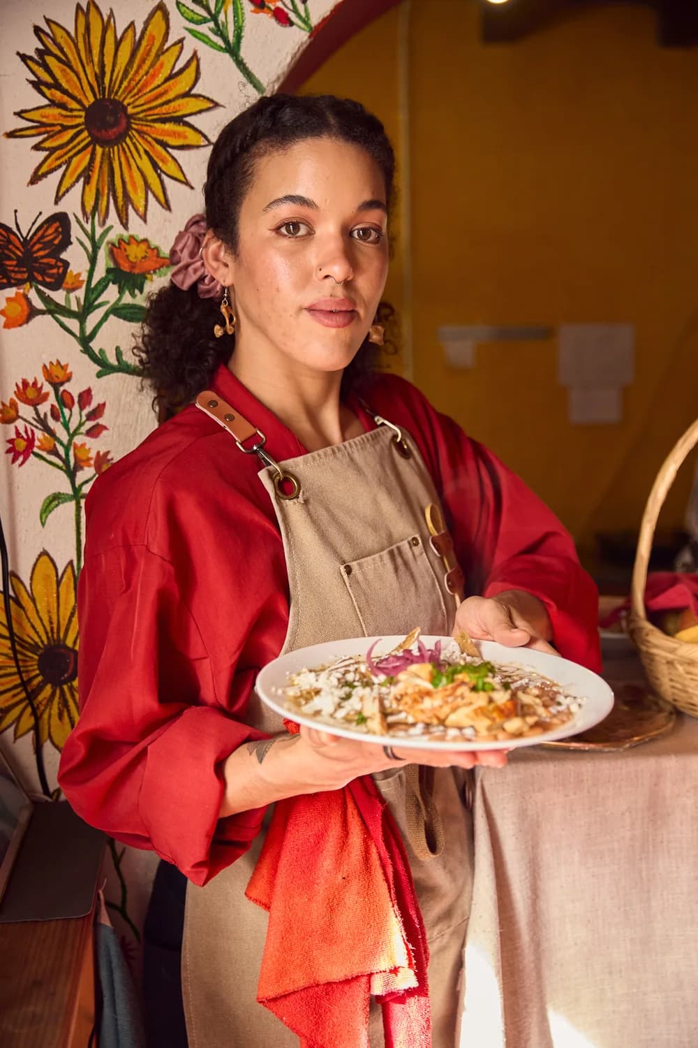 Chef Chandra holds a plated dish inside Chandra’s Cocina.